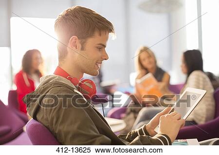 University student using digital tablet in lounge View Large Photo Image Stock Photography - University student using digital tablet in lounge. Fotosearch