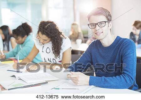Stock Photography - University student using digital tablet in classroom. Fotosearch