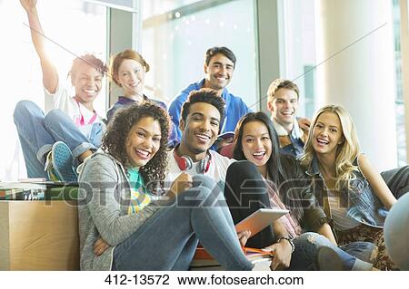 Stock Image - University students laughing together in classroom. Fotosearch