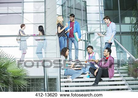 Stock Image - University students relaxing on steps. Fotosearch