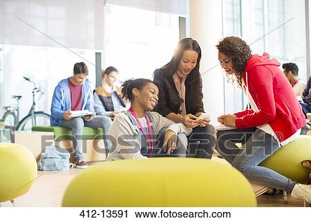 Stock Image - University students talking in lounge. Fotosearch
