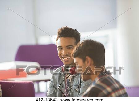 Stock Image - University students talking in lounge. Fotosearch