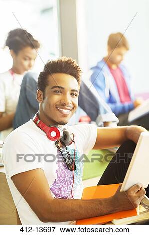 Stock Photo - University students using digital tablet in lounge. Fotosearch