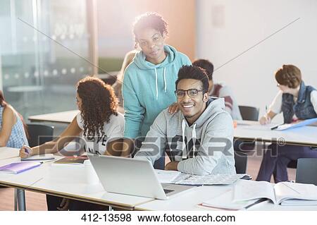 Stock Photo - University students using laptop in classroom. Fotosearch