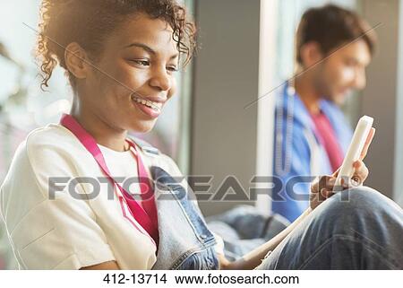 Picture - Woman using cell phone indoors. Fotosearch