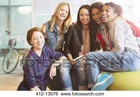 Stock Photograph - Women smiling together on beanbag. Fotosearch