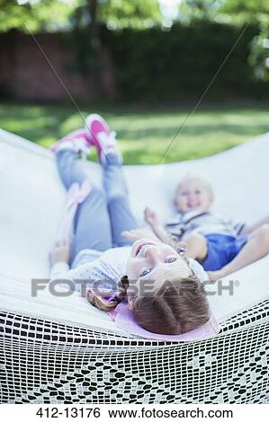 Stock Photograph - Children relaxing in hammock outdoors. Fotosearch