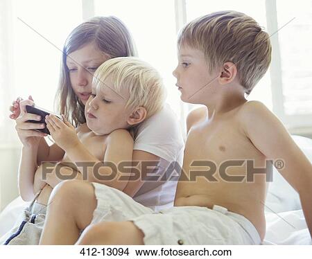 Children using cell phone together View Large Photo Image Picture - Children using cell phone together. Fotosearch