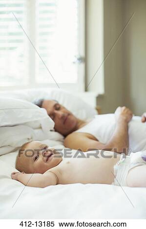 Father and baby relaxing on bed View Large Photo Image Stock Photography - Father and baby relaxing on bed. Fotosearch