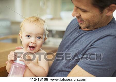 Stock Photo - Father and baby sitting in kitchen. Fotosearch