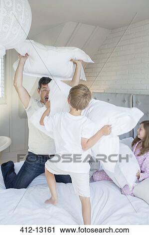 Father and children having pillow fight View Large Photo Image Stock Image - Father and children having pillow fight. Fotosearch