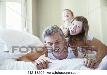 Father and children playing on bed View Large Photo Image Picture - Father and children playing on bed. Fotosearch