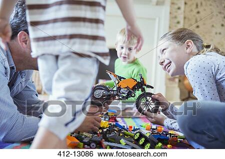 Stock Photograph - Father and children playing together. Fotosearch