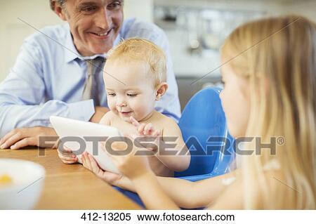 Father and children using digital tablet at table View Large Photo Image Stock Photography - Father and children using digital tablet at table. Fotosearch