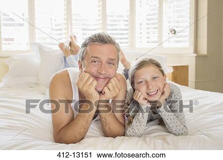 Father and daughter laying on bed View Large Photo Image Stock Image - Father and daughter laying on bed. Fotosearch