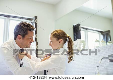 Father and daughter tying each other's ties View Large Photo Image Picture - Father and daughter tying each other's ties. Fotosearch