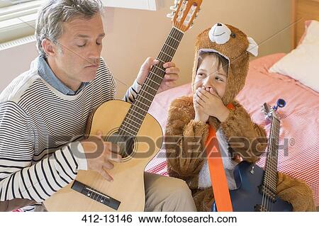 Father and son playing guitar together View Large Photo Image Stock Photograph - Father and son playing guitar together. Fotosearch