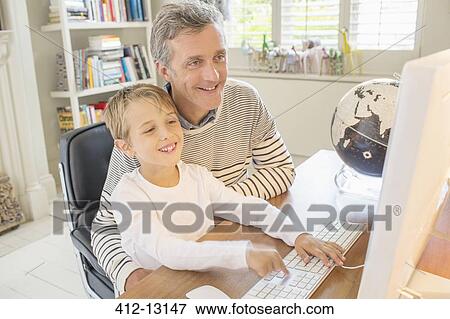 Father and son using computer together View Large Photo Image Stock Photo - Father and son using computer together. Fotosearch