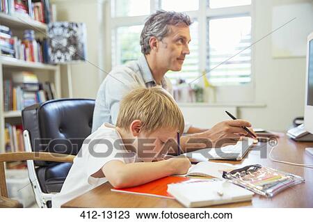 Stock Image - Father and son working in home office. Fotosearch