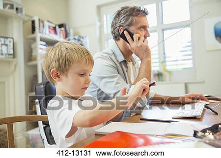 Father and son working in home office View Large Photo Image Stock Image - Father and son working in home office. Fotosearch