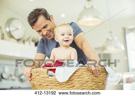 Father carrying baby in laundry basket View Large Photo Image Stock Image - Father carrying baby in laundry basket. Fotosearch