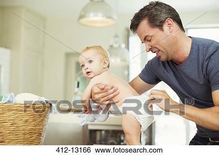 Father checking baby's diaper View Large Photo Image Stock Photograph - Father checking baby's diaper. Fotosearch