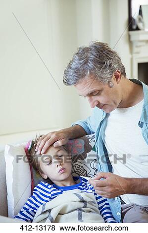 Stock Photo - Father checking son's temperature. Fotosearch
