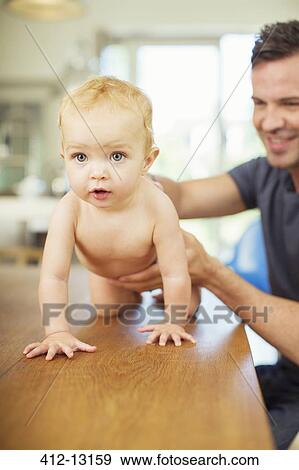 Father helping baby crawl on table View Large Photo Image Stock Photo - Father helping baby crawl on table. Fotosearch