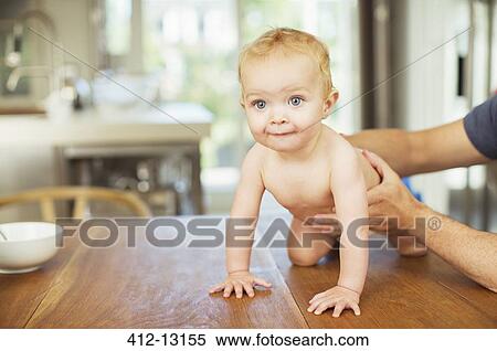 Father helping baby crawl on table View Large Photo Image Stock Photography - Father helping baby crawl on table. Fotosearch