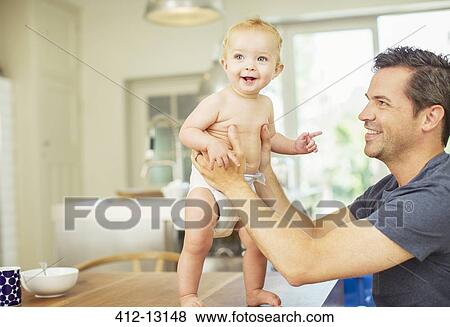 Father helping baby walk on table View Large Photo Image Stock Photo - Father helping baby walk on table. Fotosearch