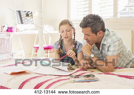 Father helping daughter with homework View Large Photo Image Picture - Father helping daughter with homework. Fotosearch