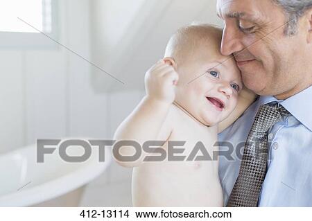 Father holding baby in bathroom View Large Photo Image Picture - Father holding baby in bathroom. Fotosearch
