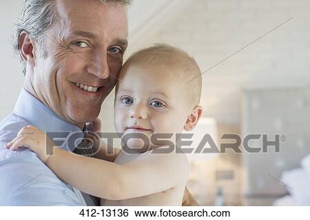 Father holding baby in bedroom View Large Photo Image Stock Photograph - Father holding baby in bedroom. Fotosearch