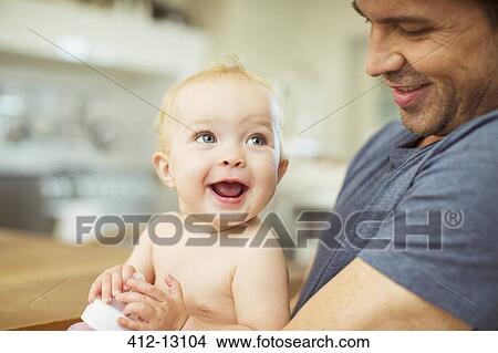 Father holding baby in kitchen View Large Photo Image Picture - Father holding baby in kitchen. Fotosearch