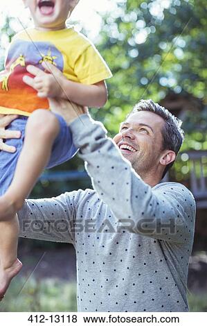 Stock Photo - Father playing with son outdoors. Fotosearch