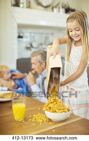 Girl pouring bowl cereal on breakfast table View Large Photo Image Stock Image - Girl pouring bowl cereal on breakfast table. Fotosearch