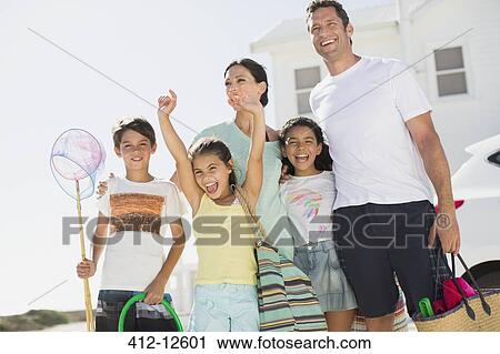 Stock Image - Enthusiastic family with beach gear. Fotosearch