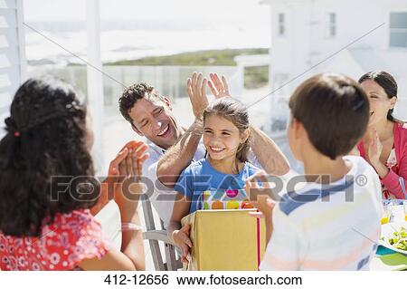 Family celebrating birthday on sunny patio View Large Photo Image Stock Photograph - Family celebrating birthday on sunny patio. Fotosearch