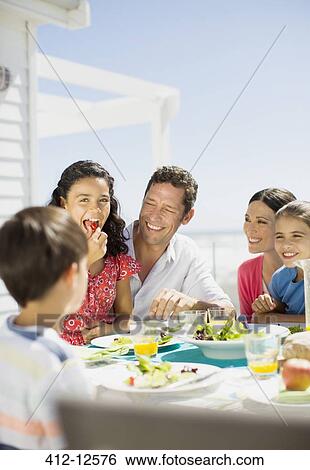 Family eating lunch on sunny patio View Large Photo Image Stock Photograph - Family eating lunch on sunny patio. Fotosearch