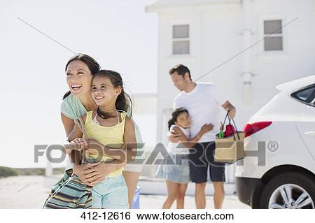 Family hugging in sunny driveway View Large Photo Image Stock Photograph - Family hugging in sunny driveway. Fotosearch