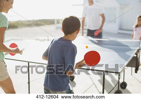 Picture - Family playing table tennis together outdoors. Fotosearch