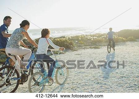Family riding bicycles on sunny beach View Large Photo Image Picture - Family riding bicycles on sunny beach. Fotosearch