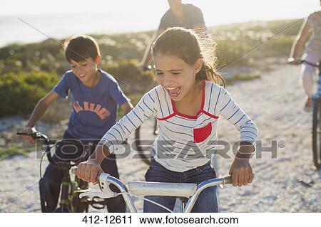 Family riding bicycles on sunny beach View Large Photo Image Stock Image - Family riding bicycles on sunny beach. Fotosearch