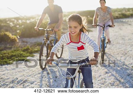 Family riding bicycles on sunny beach View Large Photo Image Stock Image - Family riding bicycles on sunny beach. Fotosearch