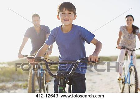 Family riding bicycles on sunny beach View Large Photo Image Stock Image - Family riding bicycles on sunny beach. Fotosearch