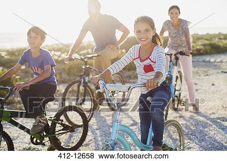 Family riding bicycles on sunny beach View Large Photo Image Stock Photo - Family riding bicycles on sunny beach. Fotosearch