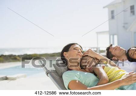 Family sleeping in lounge chairs at poolside View Large Photo Image Stock Photograph - Family sleeping in lounge chairs at poolside. Fotosearch