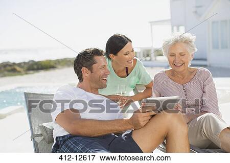 Family using digital tablet at poolside View Large Photo Image Stock Photo - Family using digital tablet at poolside. Fotosearch