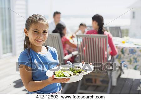 Girl holding salad on sunny patio View Large Photo Image Stock Image - Girl holding salad on sunny patio. Fotosearch