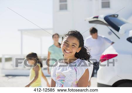 Stock Photography - Girl smiling in sunny driveway. Fotosearch